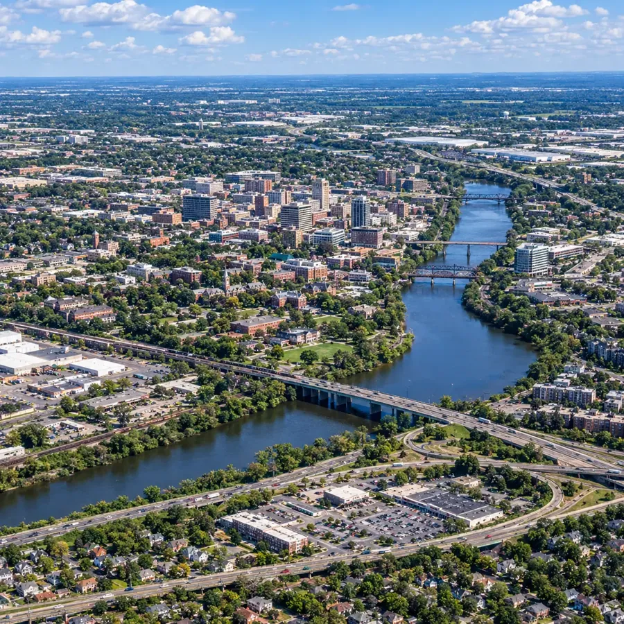 Aerial view of a river winding through a city with roads and bridges